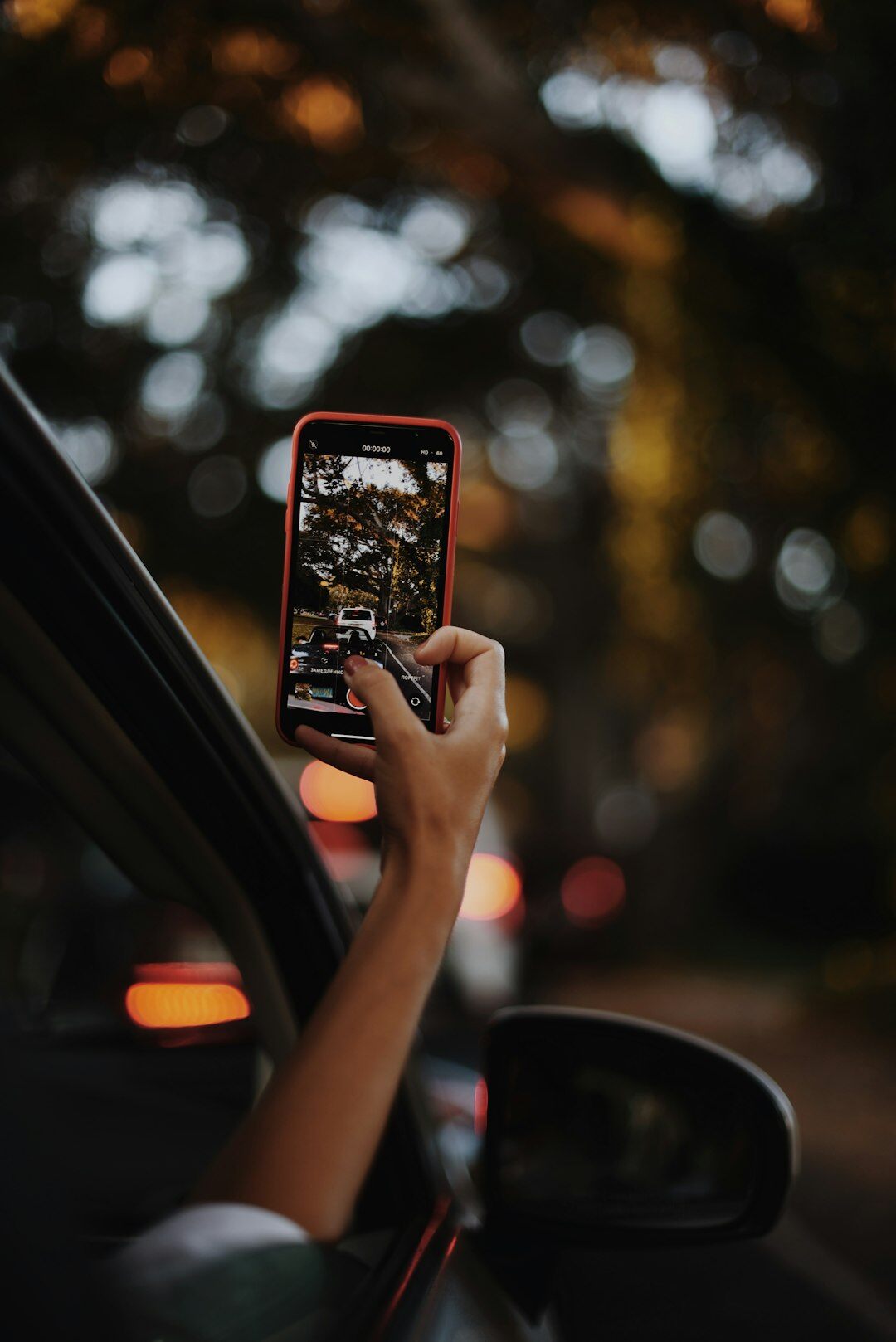 Person photographing a car with a smartphone to create a listing