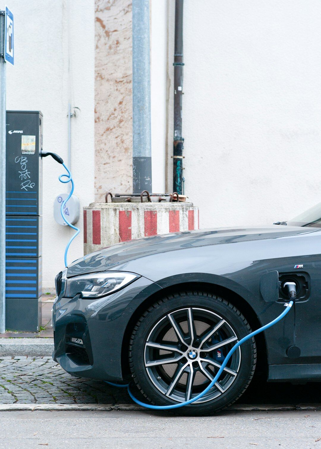 Blue electric car charging at a modern charging station